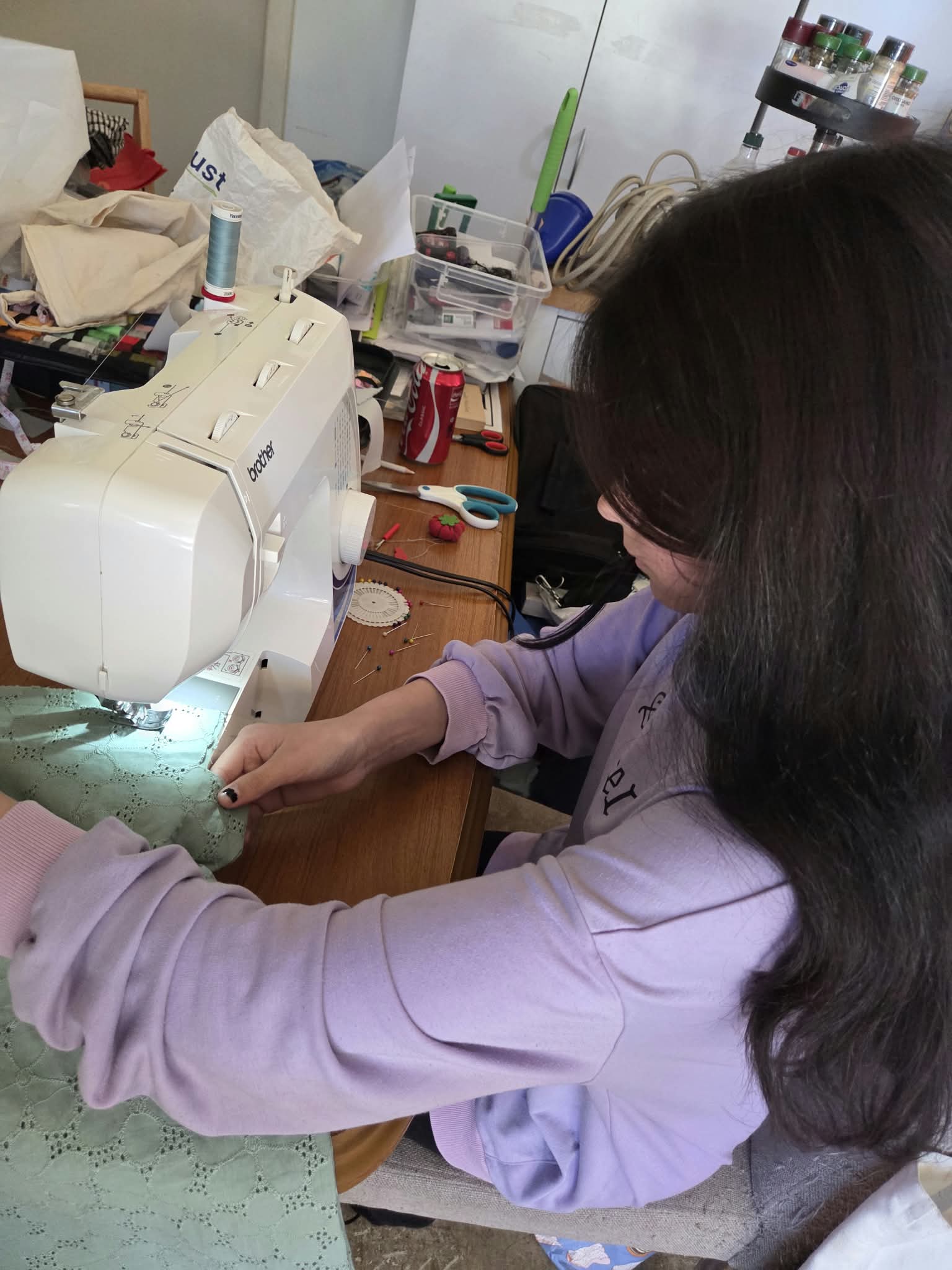 A young woman working on a sewing project at a sewing machine